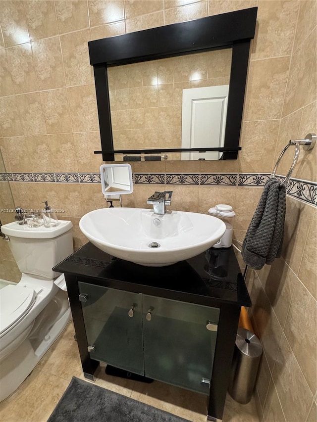 bathroom featuring vanity, toilet, tile walls, and tile patterned floors