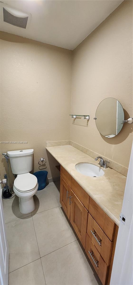 bathroom with vanity, toilet, and tile patterned flooring