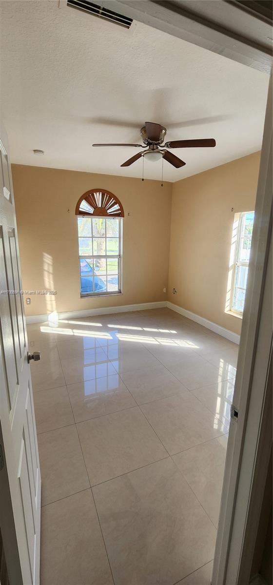 spare room featuring light tile patterned flooring and ceiling fan