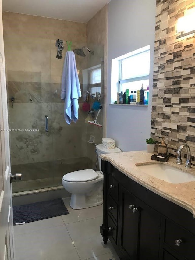 bathroom with vanity, tile patterned floors, toilet, and walk in shower