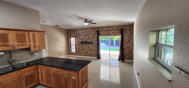 kitchen featuring sink, backsplash, a textured ceiling, and kitchen peninsula