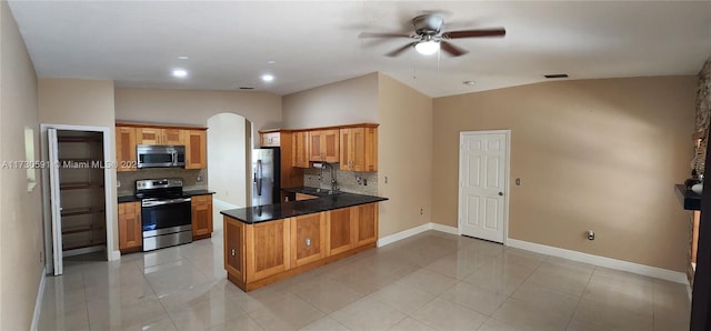 kitchen featuring appliances with stainless steel finishes, tasteful backsplash, sink, light tile patterned floors, and kitchen peninsula