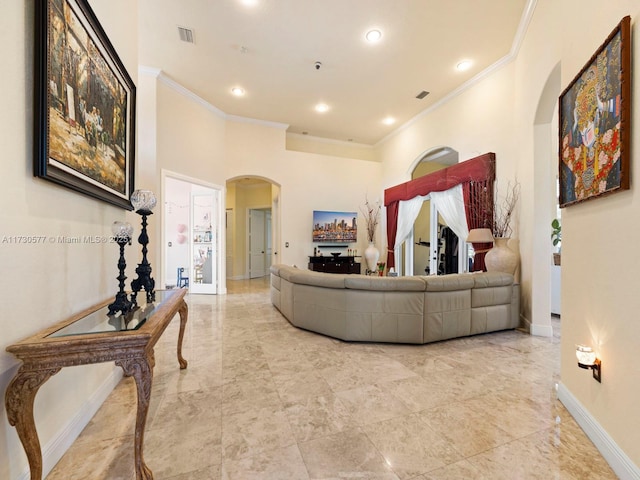 living room with ornamental molding and a high ceiling