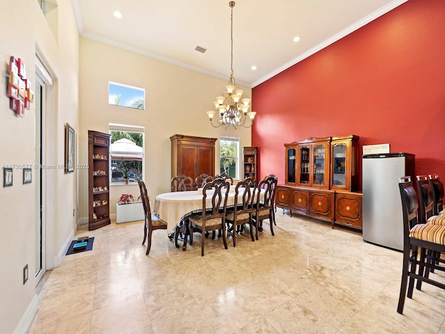 dining area with crown molding, a notable chandelier, and a high ceiling