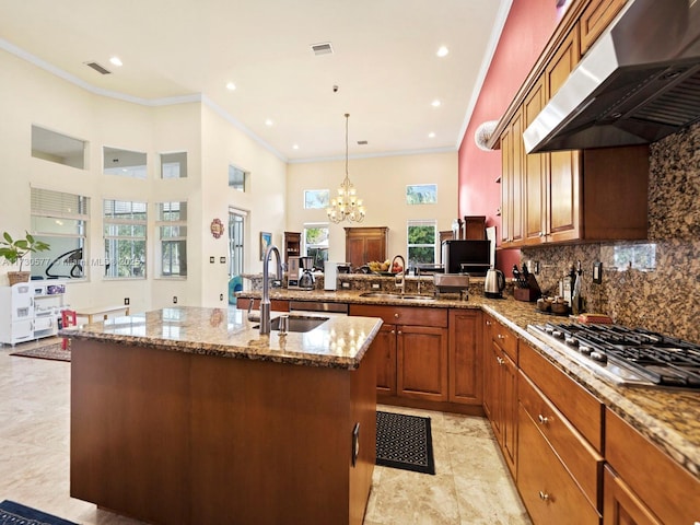 kitchen with pendant lighting, stainless steel gas cooktop, exhaust hood, and sink