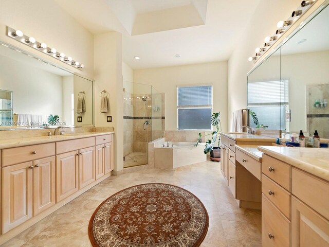 bathroom with vanity and shower with separate bathtub