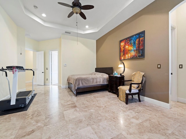 bedroom with a raised ceiling and ceiling fan