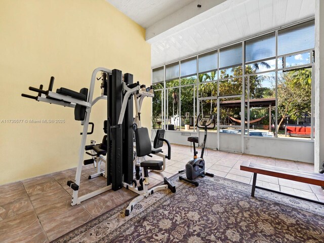 gym with a healthy amount of sunlight and tile patterned flooring