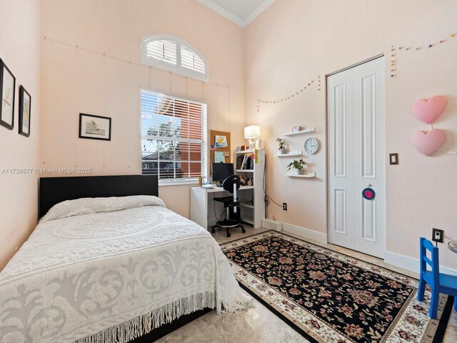 bedroom featuring crown molding and a high ceiling