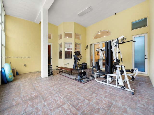 workout area featuring a towering ceiling