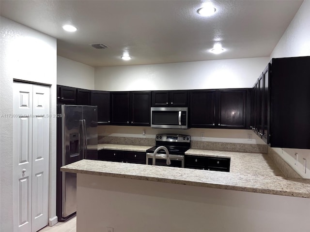 kitchen with kitchen peninsula and appliances with stainless steel finishes