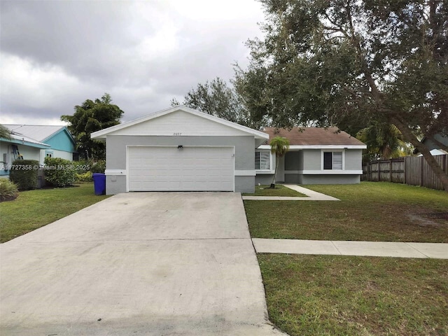 ranch-style house featuring a garage and a front lawn