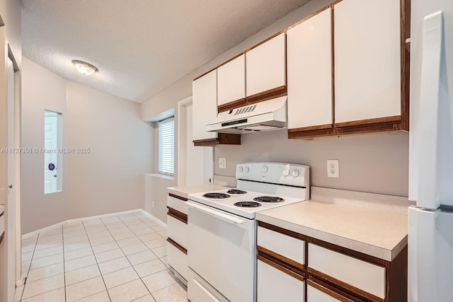 kitchen with white cabinets, white appliances, light tile patterned floors, and a textured ceiling