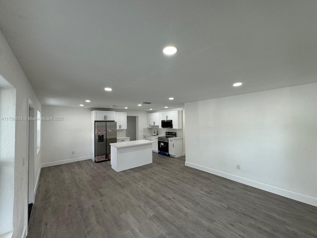 kitchen featuring stainless steel appliances, dark hardwood / wood-style floors, white cabinets, and a kitchen island