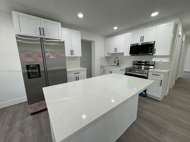 kitchen with white cabinetry, stainless steel appliances, and a center island