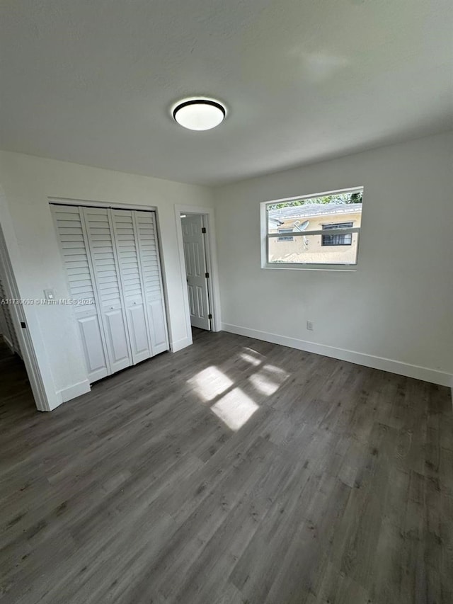 unfurnished bedroom with a closet and dark hardwood / wood-style floors