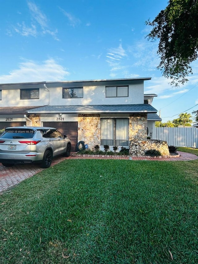 view of front of home with a garage and a front lawn