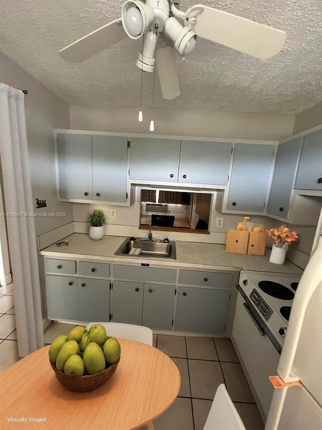 kitchen with ceiling fan, sink, light tile patterned floors, and gray cabinetry