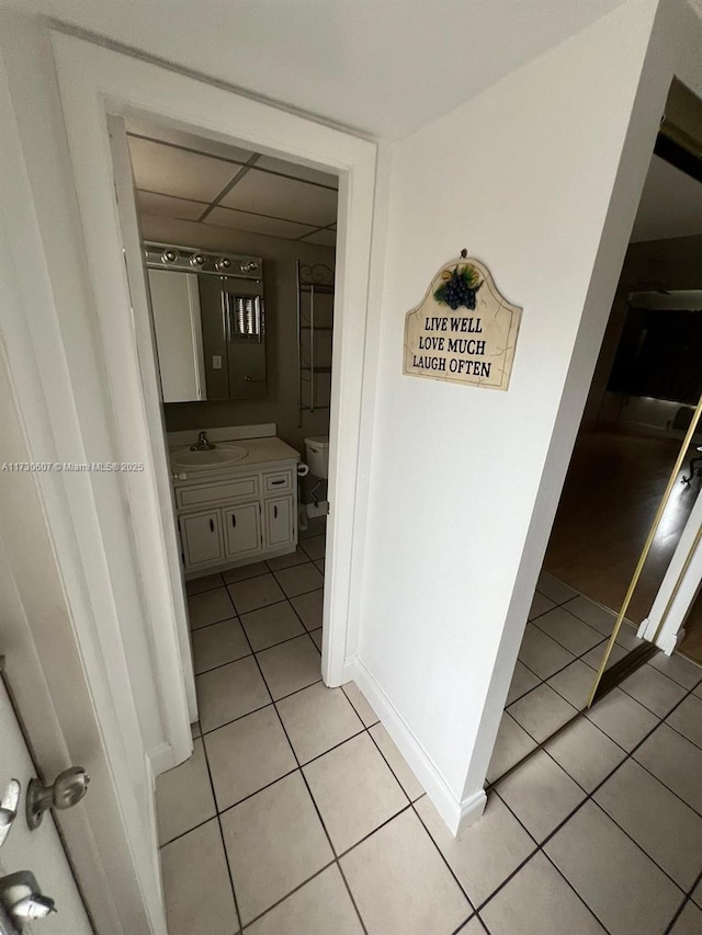 hallway featuring sink and light tile patterned floors