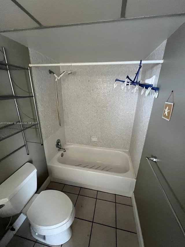 bathroom with toilet, tile patterned floors, and tiled shower / bath combo