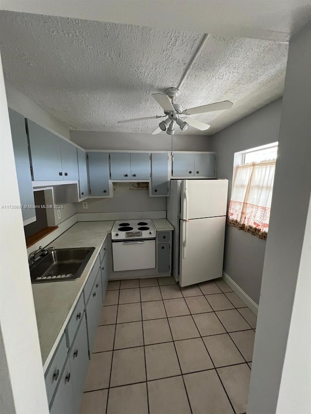 kitchen with white appliances, a textured ceiling, sink, ceiling fan, and light tile patterned flooring