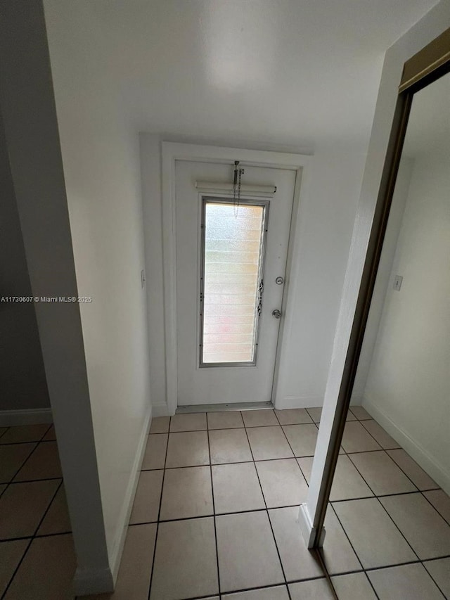 doorway to outside with light tile patterned floors