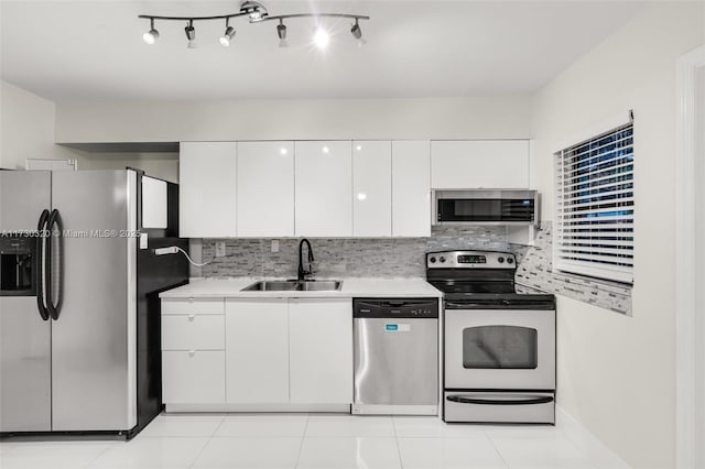 kitchen featuring light tile patterned flooring, tasteful backsplash, white cabinetry, sink, and stainless steel appliances