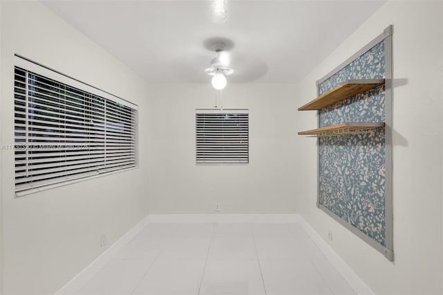 tiled empty room featuring ceiling fan