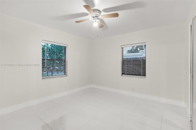 spare room featuring light tile patterned flooring, plenty of natural light, and ceiling fan