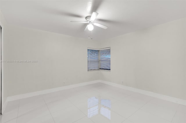 empty room with ceiling fan and light tile patterned floors