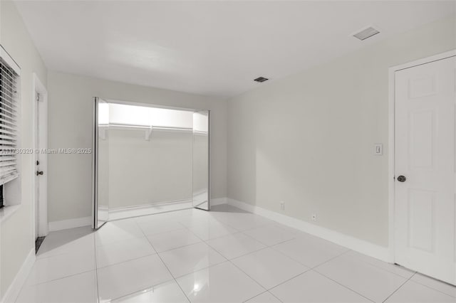 unfurnished bedroom with light tile patterned floors and a closet