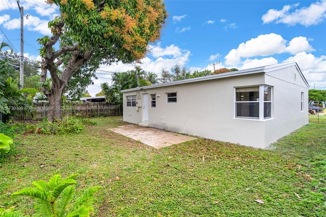 rear view of property featuring a patio area and a lawn