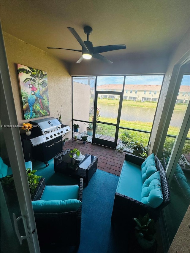 sunroom featuring a water view