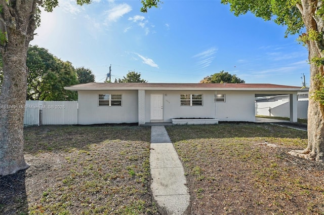 single story home featuring a front yard and a carport