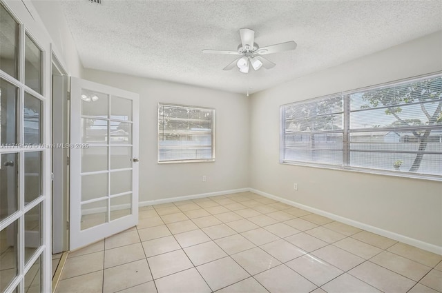 unfurnished room featuring ceiling fan, a textured ceiling, light tile patterned floors, and french doors