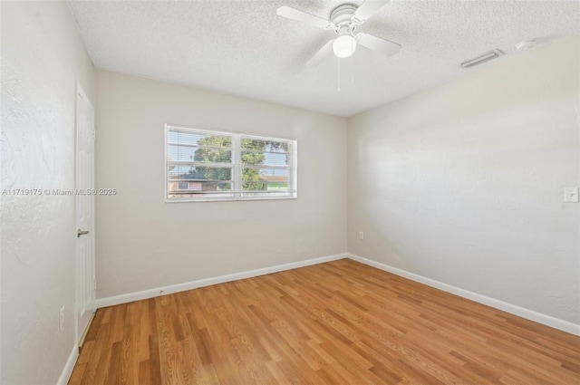 empty room featuring ceiling fan, hardwood / wood-style floors, and a textured ceiling