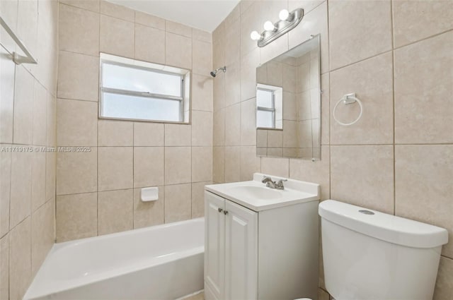 full bathroom featuring vanity, toilet, tile walls, and tiled shower / bath combo