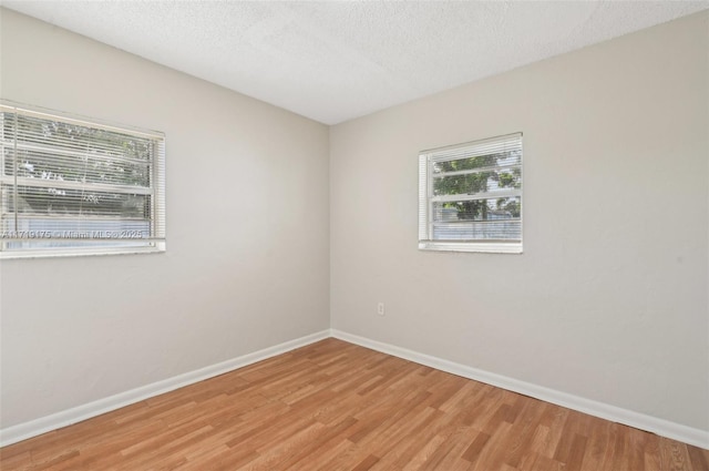 spare room with hardwood / wood-style flooring and a textured ceiling