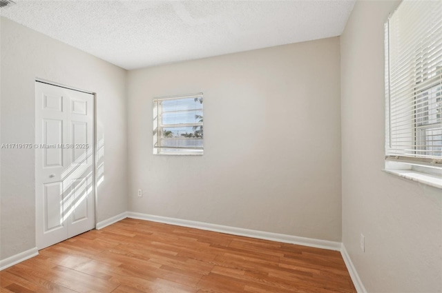 unfurnished bedroom with hardwood / wood-style floors and a textured ceiling