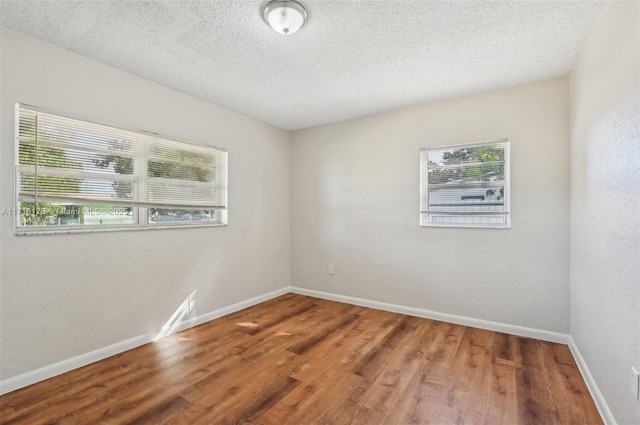 empty room featuring hardwood / wood-style flooring and a textured ceiling