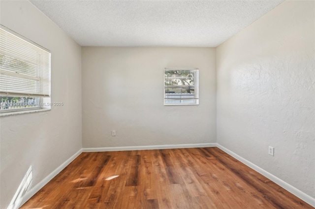 empty room featuring a textured ceiling and dark hardwood / wood-style floors