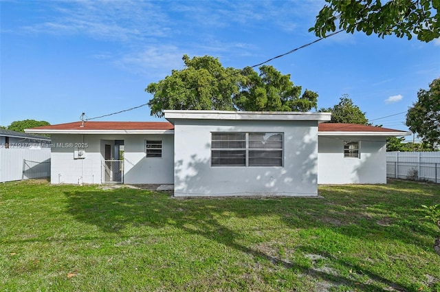 rear view of property featuring a lawn