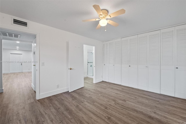 unfurnished bedroom with ceiling fan, hardwood / wood-style floors, and a closet