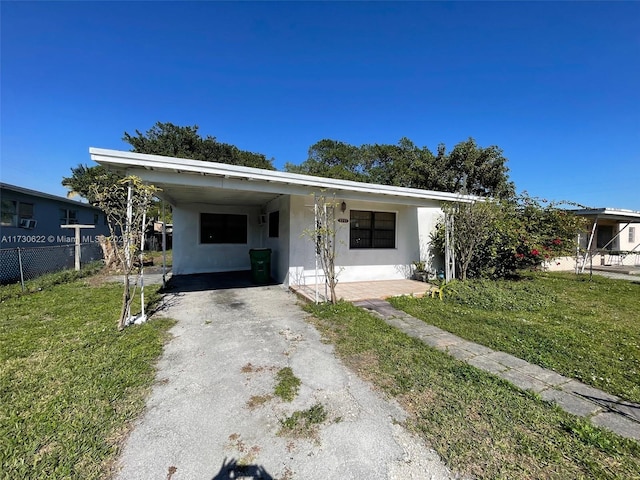 view of front of property with a front yard and a carport