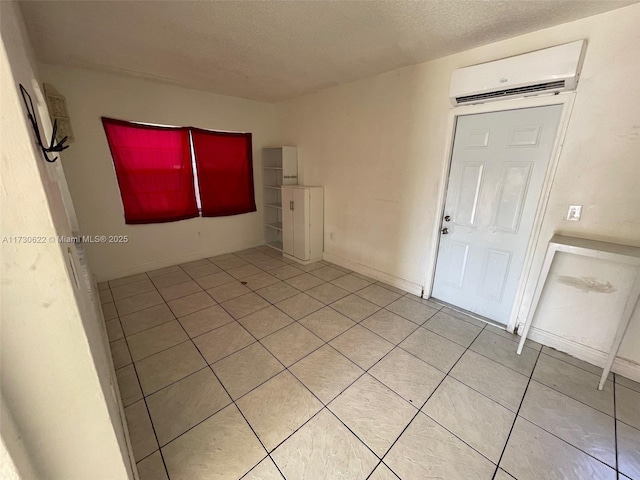 unfurnished room with an AC wall unit and a textured ceiling