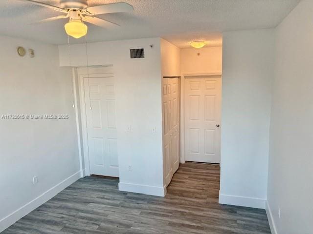 unfurnished room with ceiling fan, dark hardwood / wood-style floors, and a textured ceiling