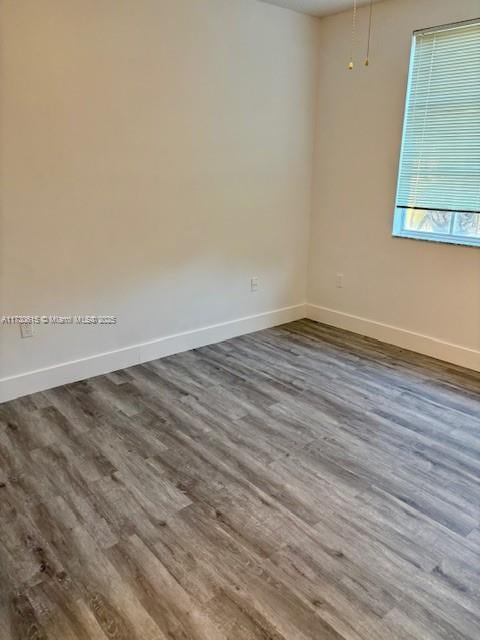 empty room with dark hardwood / wood-style flooring