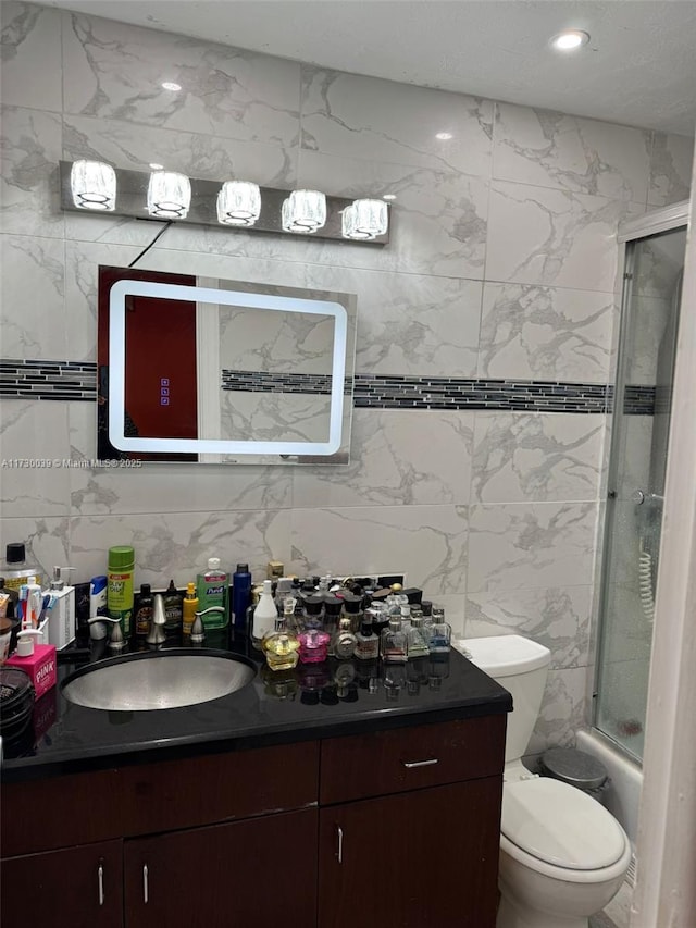 full bathroom with toilet, vanity, shower / bath combination with glass door, and tile walls