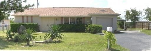 ranch-style house with a garage and a front yard