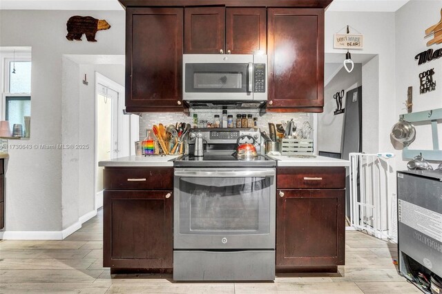 kitchen with decorative backsplash, a textured ceiling, stainless steel appliances, and light wood-type flooring